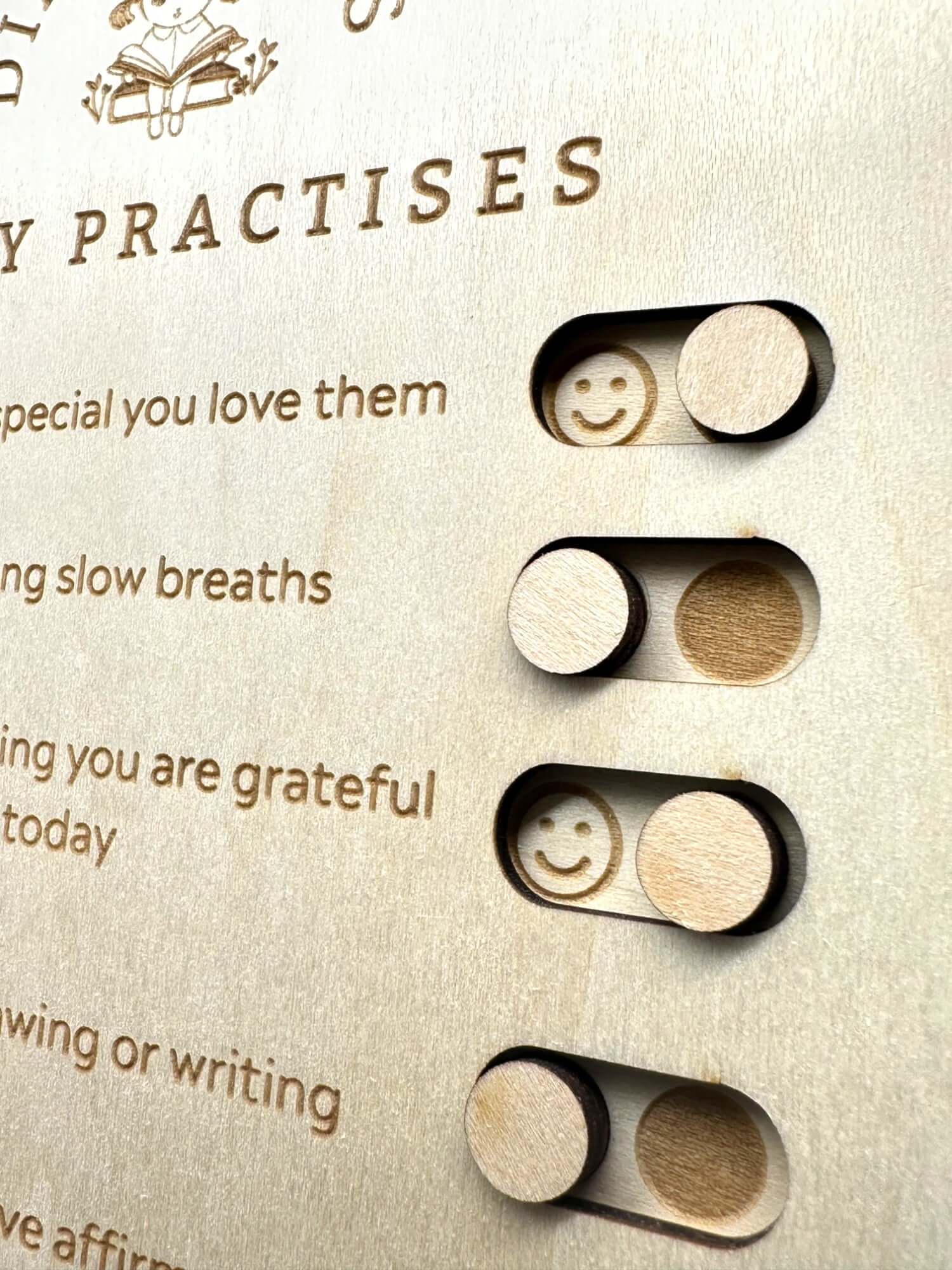 Wooden board with smiley face sliders for daily gratitude practices and mindfulness activities.