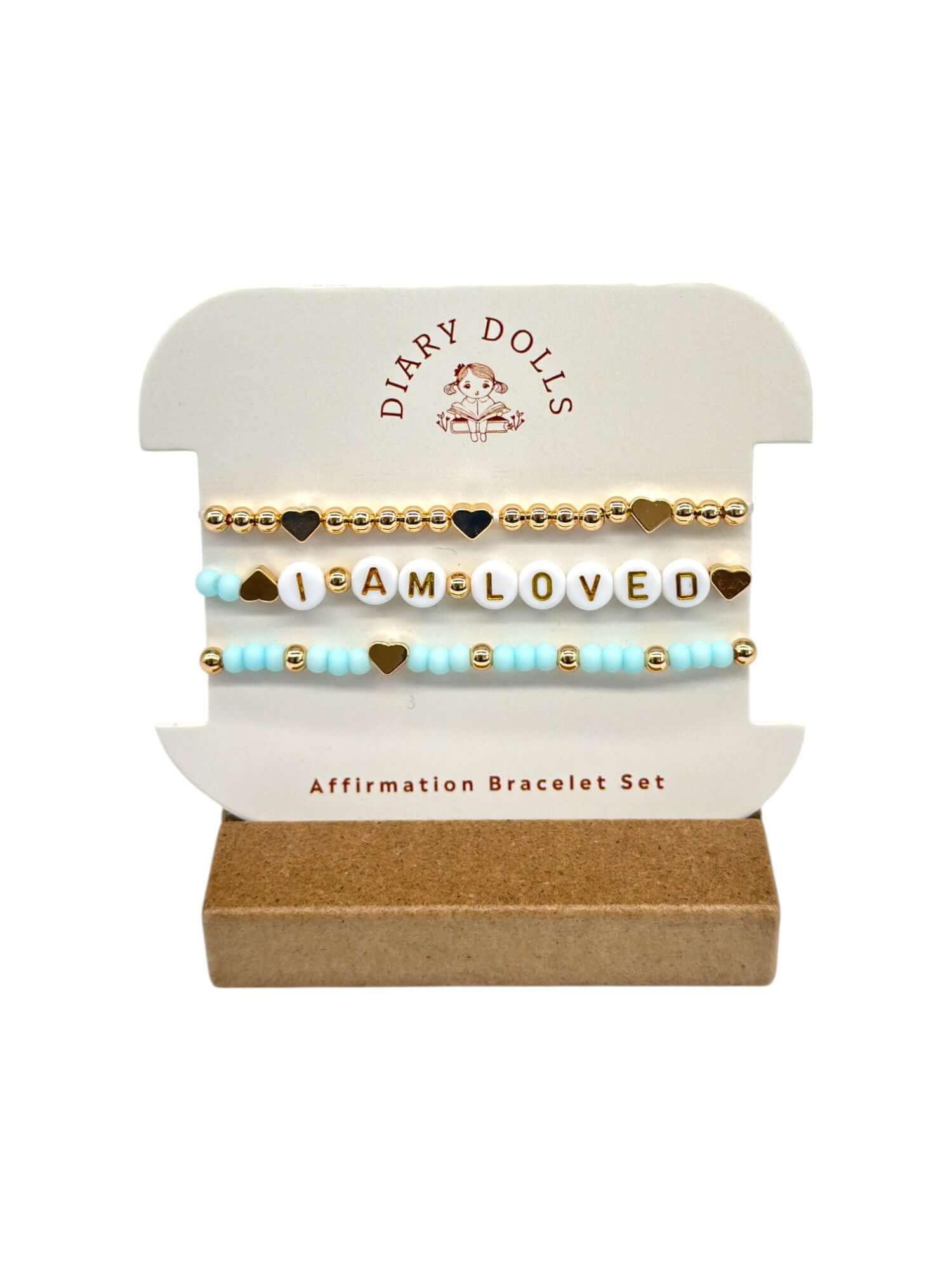 The Daily Affirmation Bundle featuring a plush doll, affirmation book, and motivational bracelets for children's self-confidence.