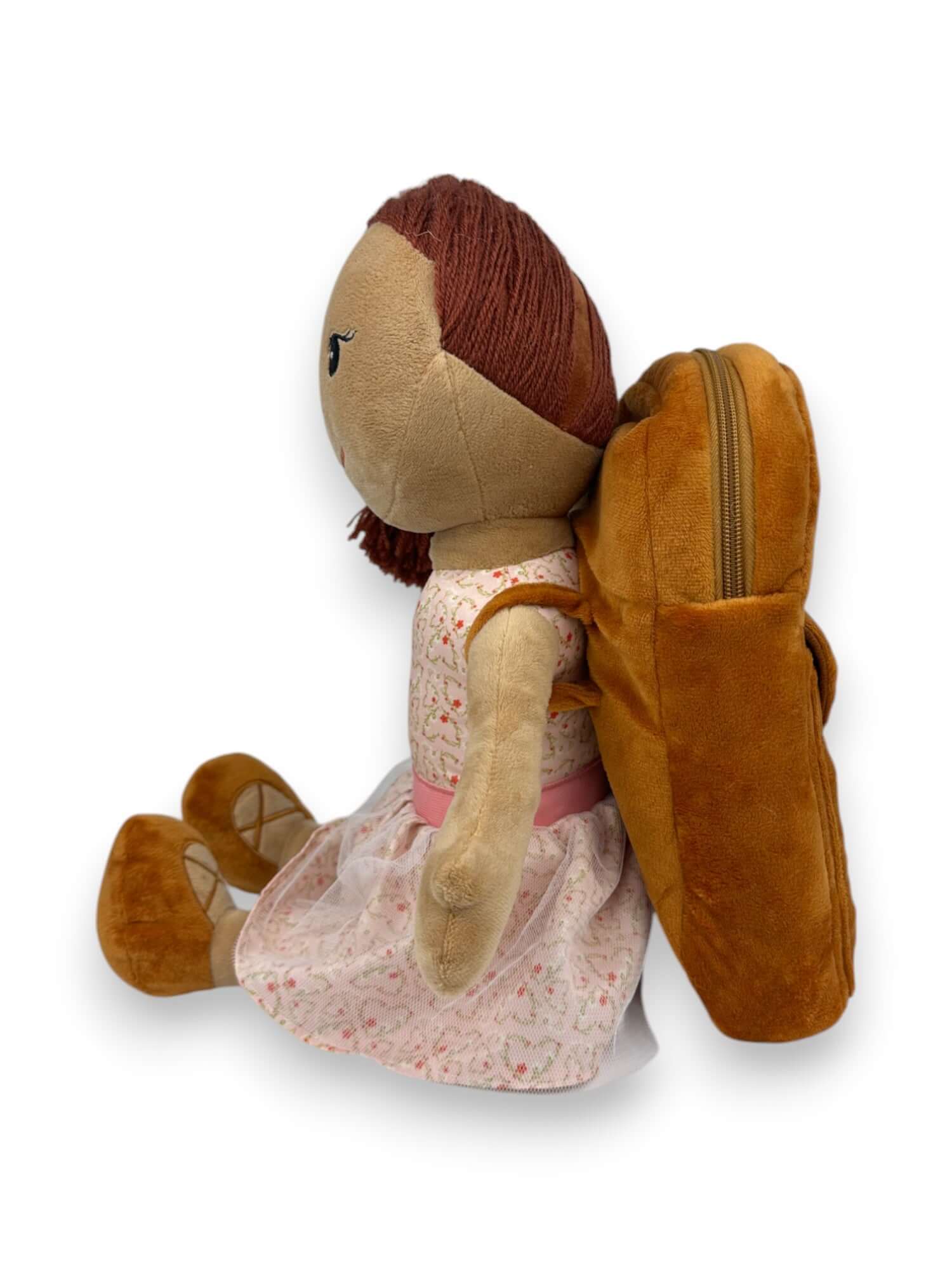 Doll with a brown backpack, dressed in a floral dress, promotes journaling and self-expression.
